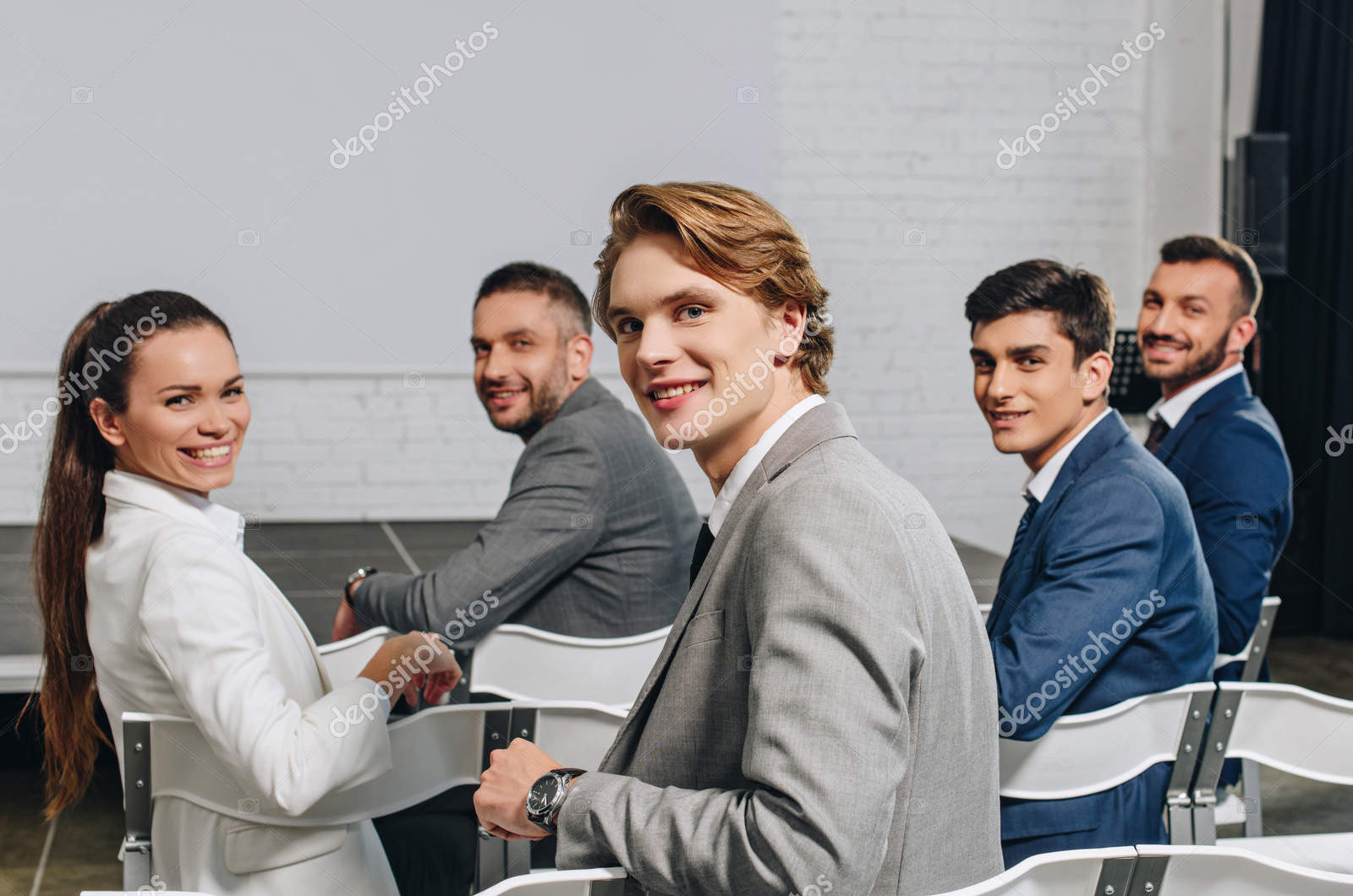 depositphotos_209197462-stock-photo-smiling-businesspeople-sitting-chairs-training
